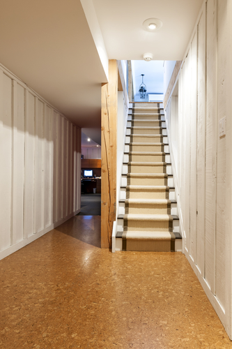 Like most parts of your home, your stairs will gradually wear out with time. Sometimes they may require a total replacement, but more often than not, they will merely need to be refinished. As they are sitting in your basement area, they are more susceptible to moisture than the rest of your house, so that rot can set in. It is important that you decide if they do need replacing, as there will be added expense if you refinish them, only to find out several months later you should have replaced them in the first instance. If you do choose to refinish your basement steps, then read our guide on the best options available to you. Painting And Staining If you have just renovated your basement or are merely looking to refinish your stairs, you should note that some homeowners don’t like to cover their stairs up, preferring their natural look. If this is you, then you might think about painting or staining them. Not only is this extremely affordable, but it also can look superb if done correctly. If you choose to stain them, then make sure that you have sanded them down properly, so that when you stain them the results will look good and the effect will last for a while. If you feel that painting your steps is the better-looking option for your home, then make sure that you use a latex floor paint. This style of paint is very durable and will last for a considerable amount of time, but of course, it will wear down eventually. You merely top it up with another lick of paint to make it look good again. One more benefit over stain is that there are plenty of colors available if you are painting, while stain only has so many. Of course, if you paint over the wooden stairs you will lose the sight of the natural grain in the wood. If you want to retain the natural look, then stain is the way to go. Carpet Many homeowners like the look and feel of carpet on their stairs. It not only makes them look new, but it also makes the stairs far easier to walk on. However, with the problem of damp and moisture in certain basements, you will find that carpet will retain any moisture and become moldy. You don’t really want your pristine cream-colored carpet spotted with mold, so really think this option through. Carpet Runner Instead of going the whole hog and laying down a mass of carpet, a carpet runner may solve your refinishing issue. Carpet runner is merely a thinner carpet that is stapled in place. This can be a viable cheaper option to full carpeted stairs, and when coupled with the rest of the step being stained in varnish, they can look good. Vinyl Some homeowners are now using vinyl to refinish their staircases, and this is a good option as it is resilient to damp and mold while being easy to clean. Vinyl flooring merely requires metal strips to hold it down and is easy to replace. It is also a cheaper option that full carpeting or expensive varnishing and staining. If you decide that none of these options are viable due to rot and dampness, you should look at replacing your basement stairs.